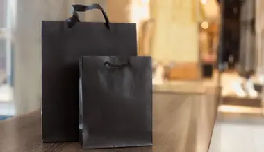 Black branded gift bags on a retail store counter