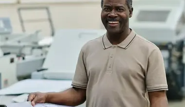 Print shop worker holding a freshly printed poster